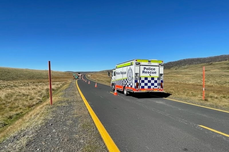 A police van on a highway in the snowy mountains