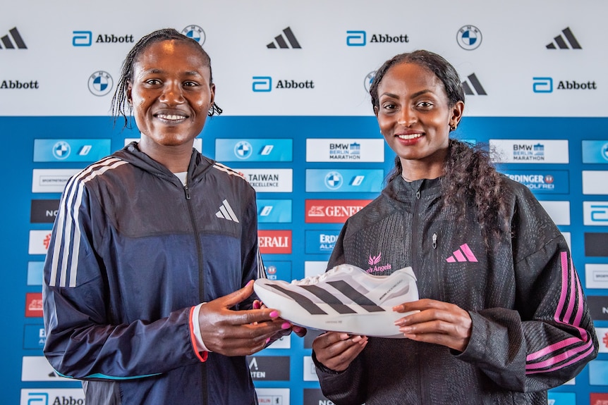 Sheila Chepkirui and Tigist Assefa hold an adidas shoe