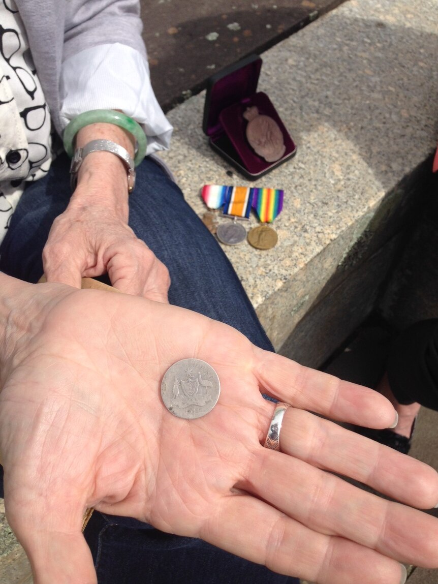 Ms Lee holds the coin Private Bryant carried with him throughout WWI.