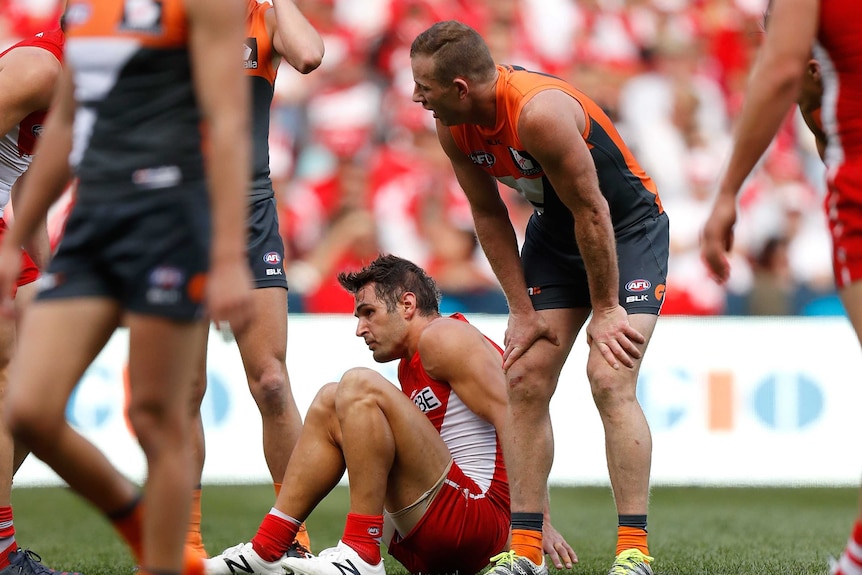 The Giants' Steve Johnson (R) looks on as Sydney's Josh Kennedy lies injured in qualifying final.