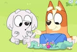 Two cartoon dogs play pass-the-parcel in an episode of Bluey.