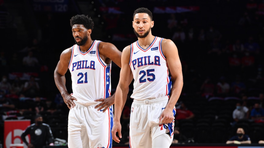 Joel Embiid and Ben Simmons both look down