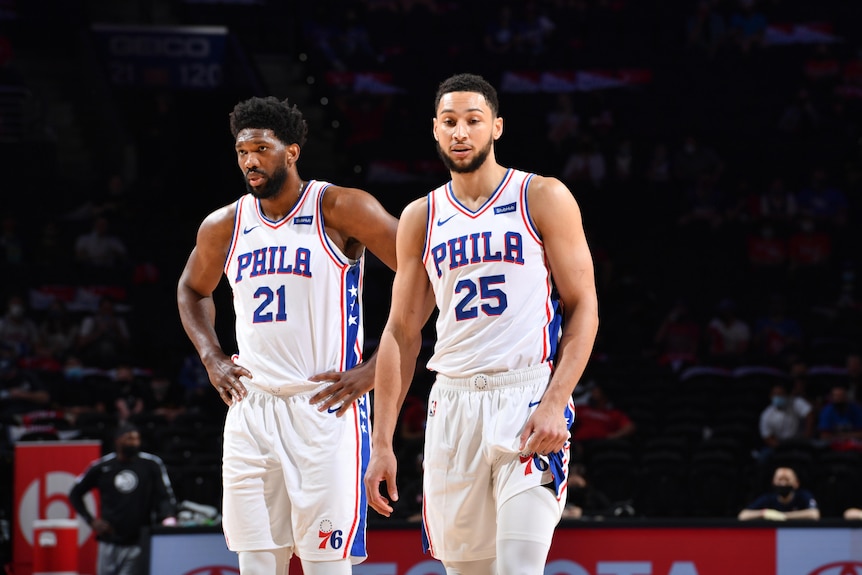 Joel Embiid and Ben Simmons both look down
