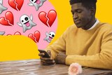 Man sits and looks sadly at phone, which has cartoon ghosts and broken hearts streaming out, in a story about rejecting dates.