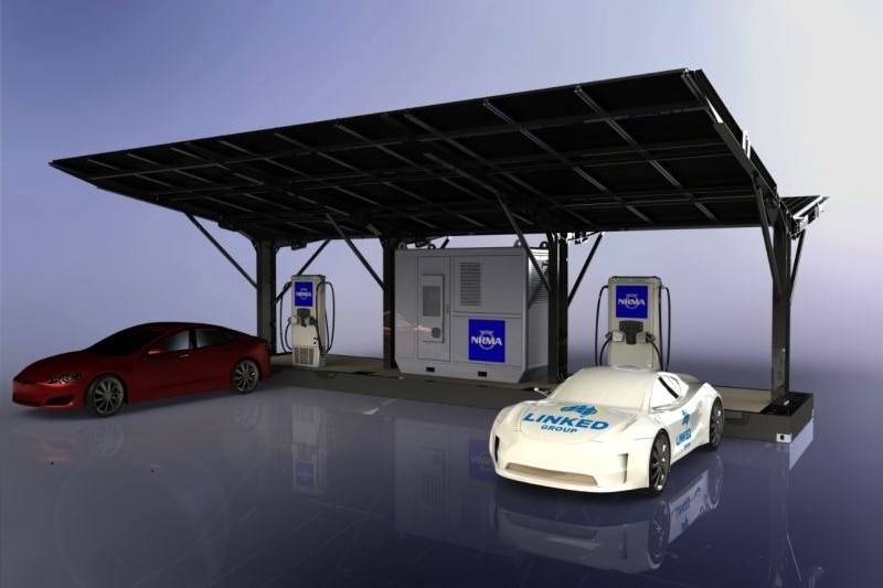 Two electric vehicles parked at an EV charging station with solar panels forming a shelter protecting the chargers.