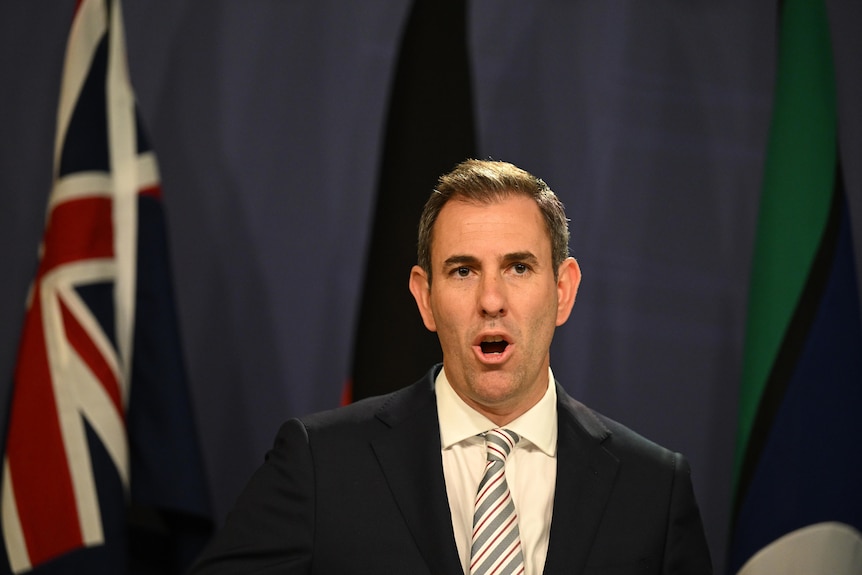 Treasurer Jim Chalmers addresses the media in front of the Australian, Aboriginal and Torres Strait Islander flags