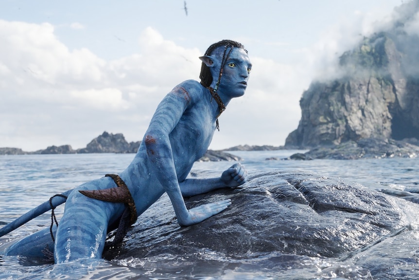 An alien emerges from the water in a still from the sci-fi film Avatar: The Way Of Water