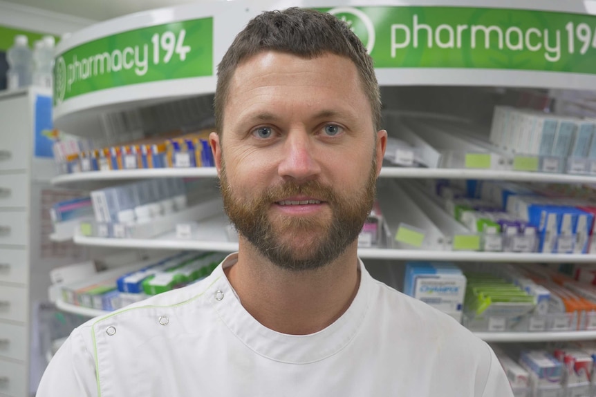 Paul Buise standing in front of pharmacy sign