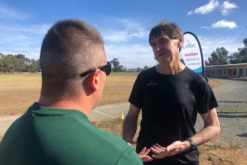 Man in black top speaks to anonymous prisoner in prison