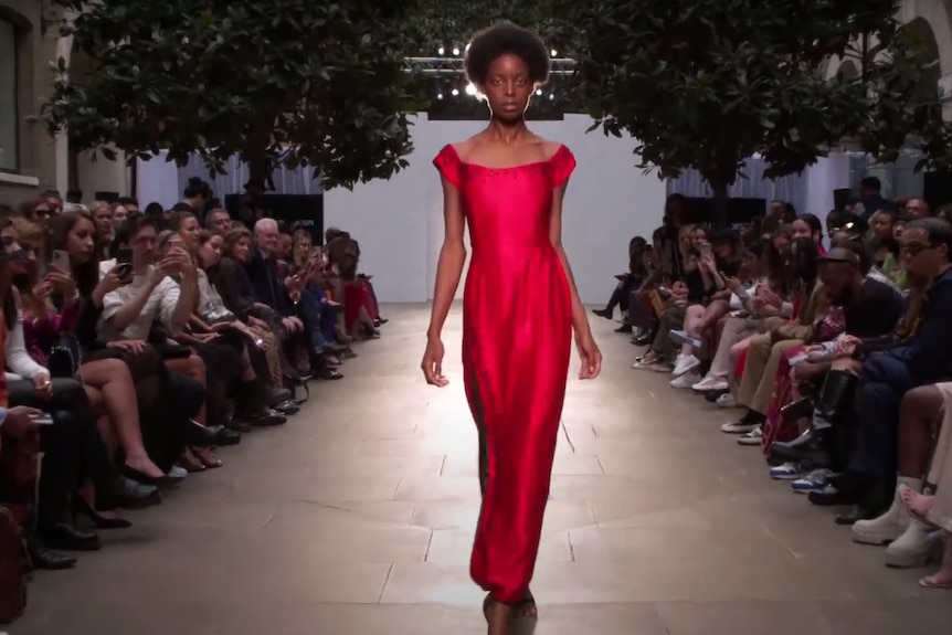 A model wearing a red dress on the catwalk