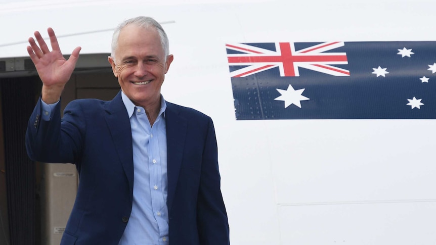 Malcolm Turnbull waves as he boards a plane
