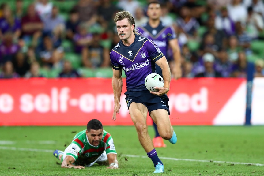 A Melbourne Storm NRL player runs with the ball against South Sydney.