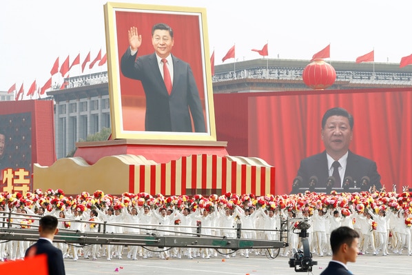 Performers travel past Tiananmen Square with a float showing a large portrait of Chinese President Xi Jinping