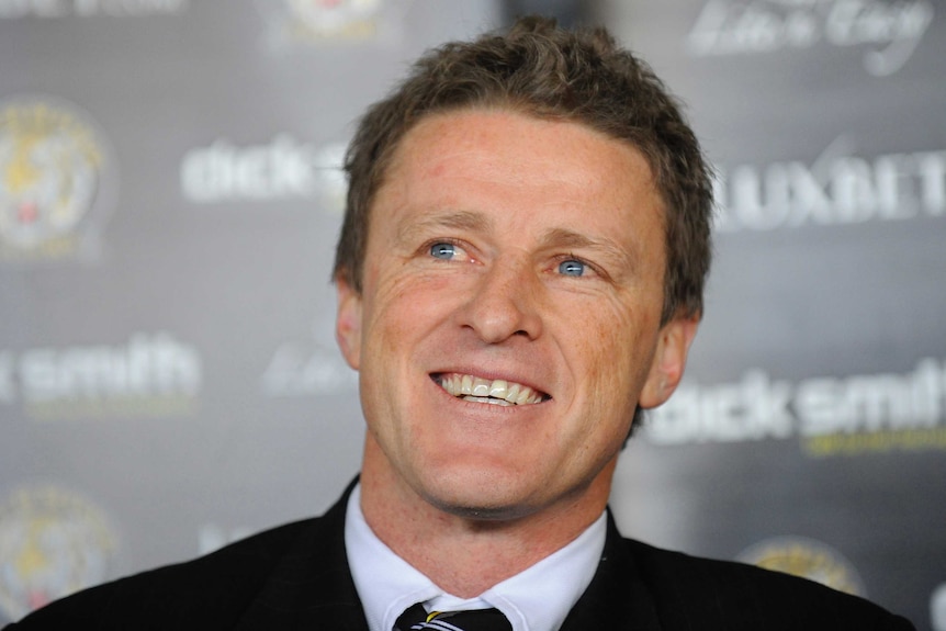 A younger-looking Damien Hardwick smiles while wearing a suit, having just been named Richmond coach