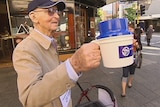 A Vinnies volunteer Tom Fisher, who is 93, appeals for donations on a main street in Perth