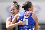 Emma Kearney and Kate Gillespie-Jones embrace as they celebrate an AFLW goal for North Melbourne against Richmond.
