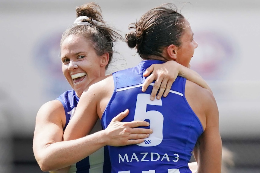 Emma Kearney and Kate Gillespie-Jones embrace as they celebrate an AFLW goal for North Melbourne against Richmond.