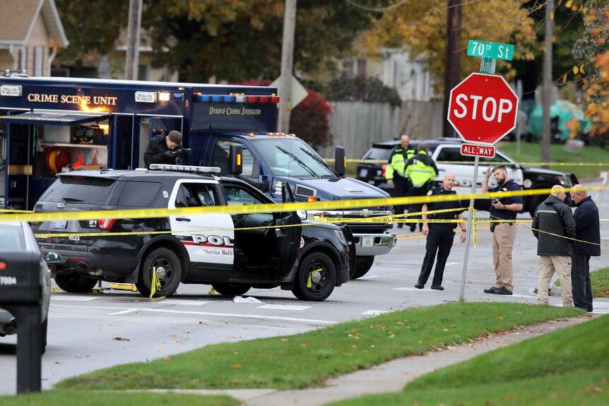 Officials investigate the scene of a police shooting in Urbandale, Iowa.