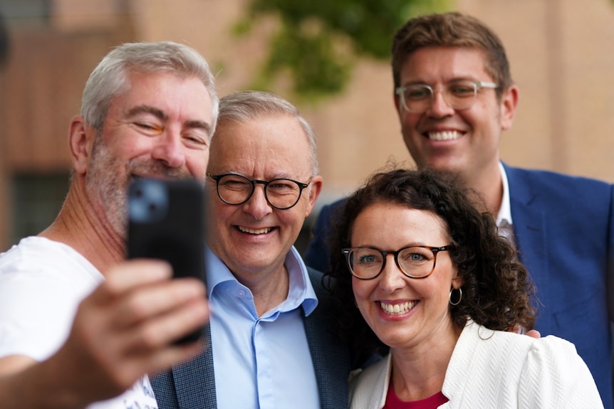 The Prime Minister Anthony Albanese poses for a selfie with three people