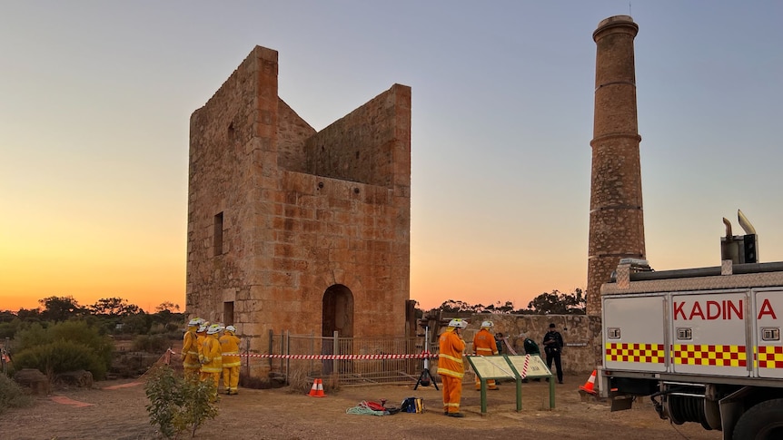A CFS truck and personnel stand outside a historic mine shaft and engine house