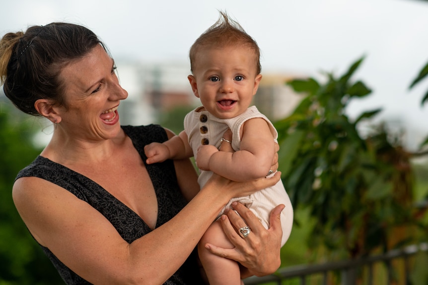 Darwin mum Aneeta Clark standing outside, holding her baby son Chesney