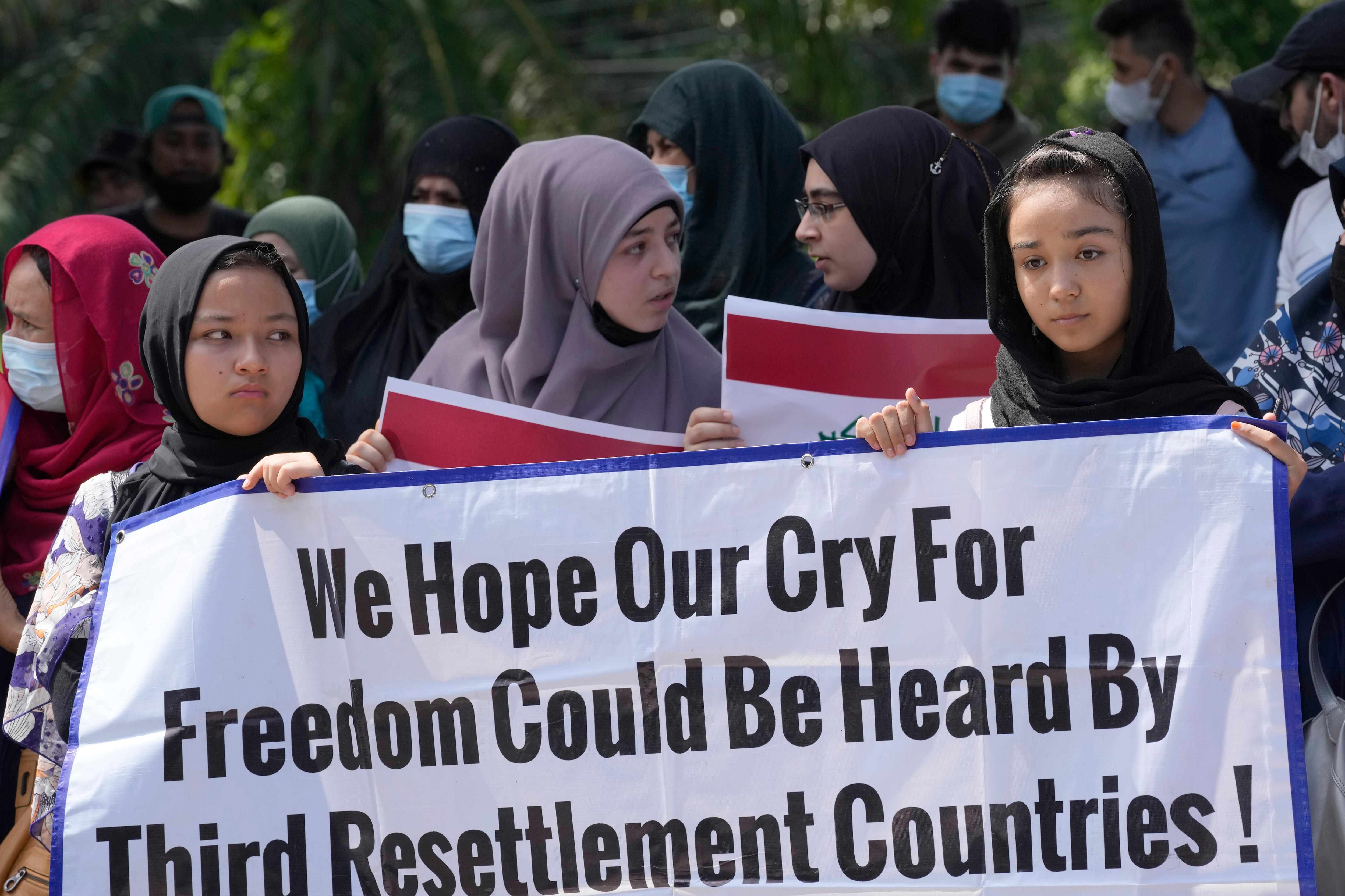 Several women hold a banner reads 'we hope our cry for freedom could be heard by third resettlement countries'