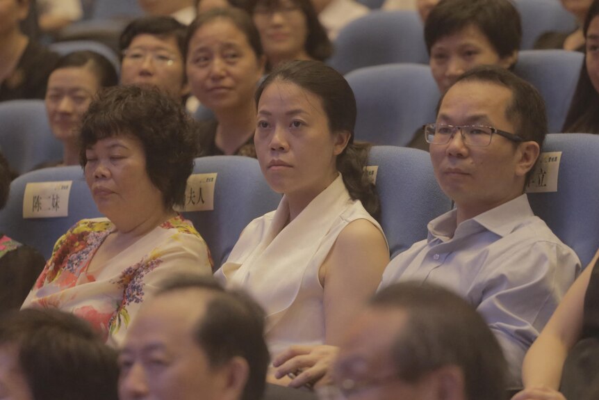 Yang Huiyan sits in an audience