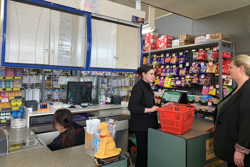 Workers behind the counter of an IGA supermarket.