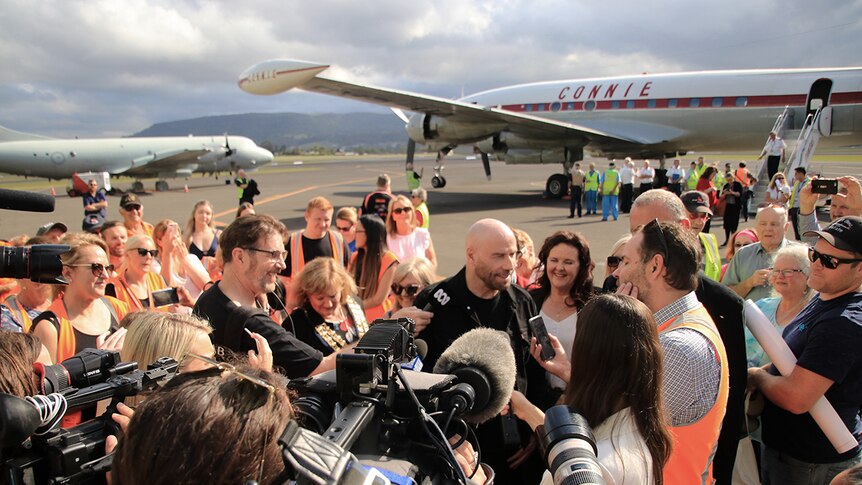 John Travolta talks to a large scrum of media at the Shellharbour Airport after a joy flight in the Connie aircraft.