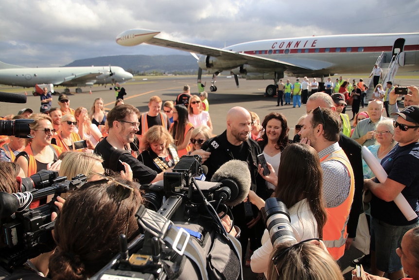 John Travolta talks to a large scrum of media at the Shellharbour Airport after a joy flight in the Connie aircraft.