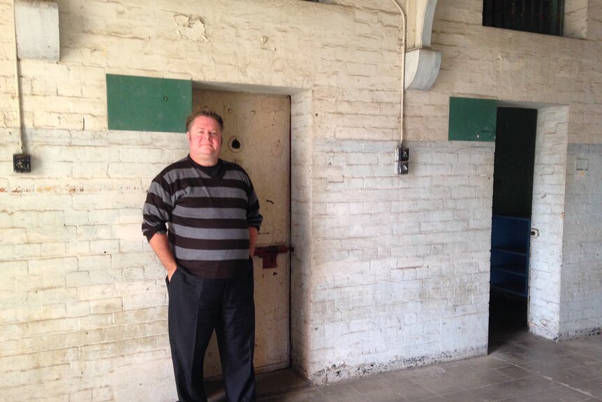 Director Jack Sim stands outside on the of the prison cell blocks.