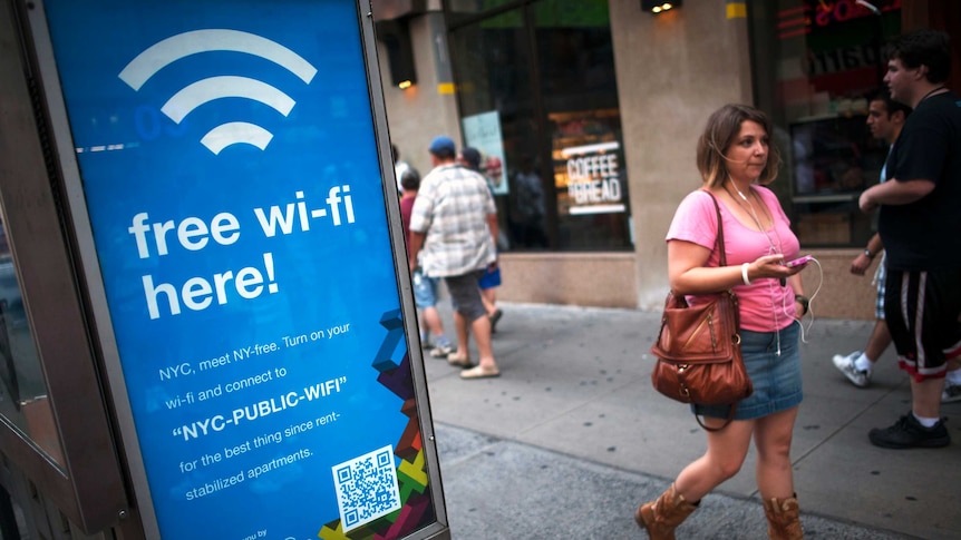 A woman walks past a WiFi-enabled phone booth in New York July 12, 2012