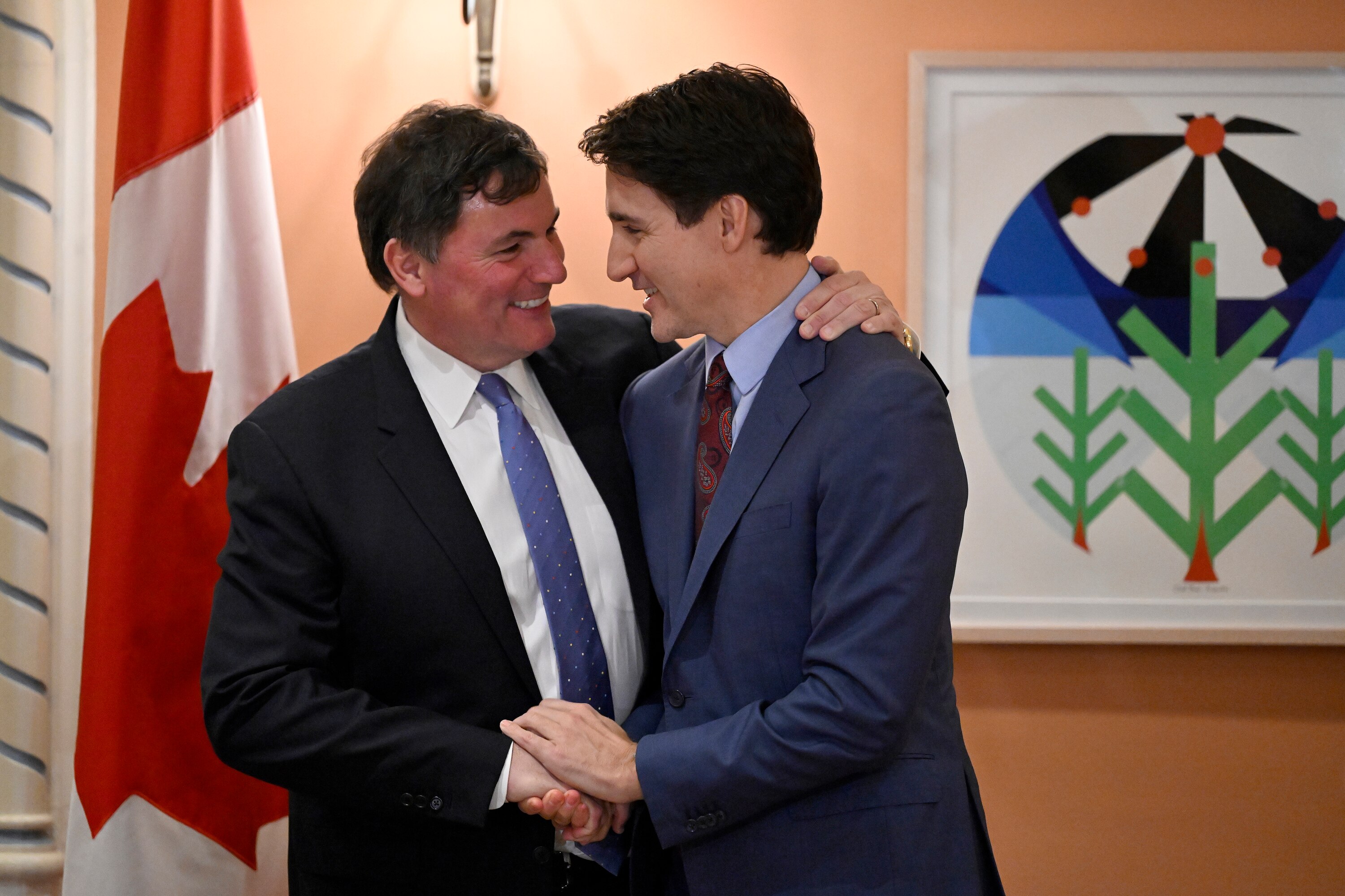 Two men in suits hug each other 