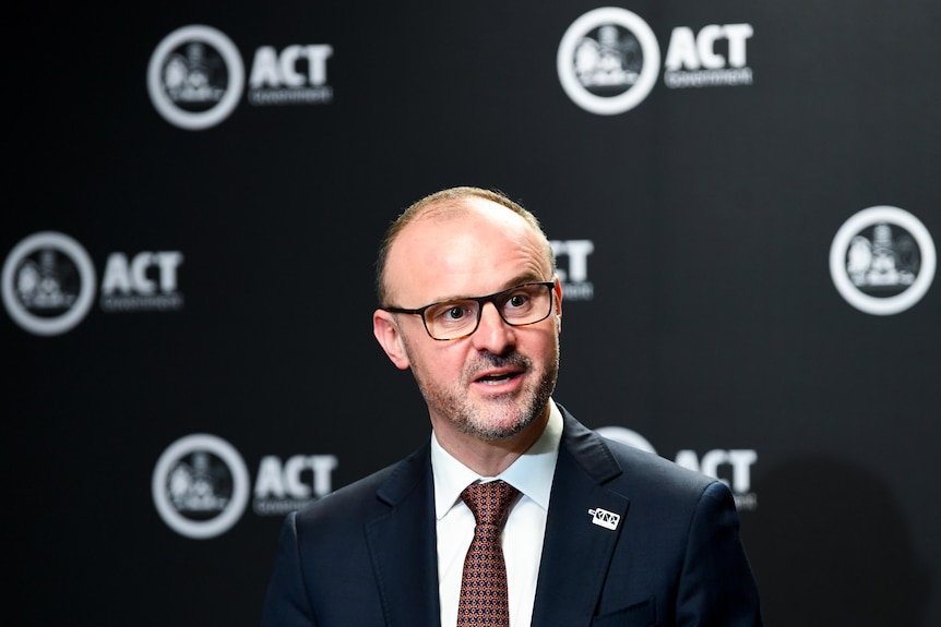 Andrew Barr in front of a background with the ACT government logo on it.