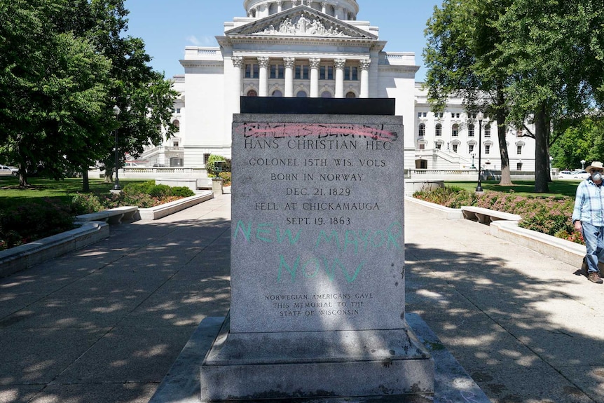 Base of statue with main figure removed sits in park