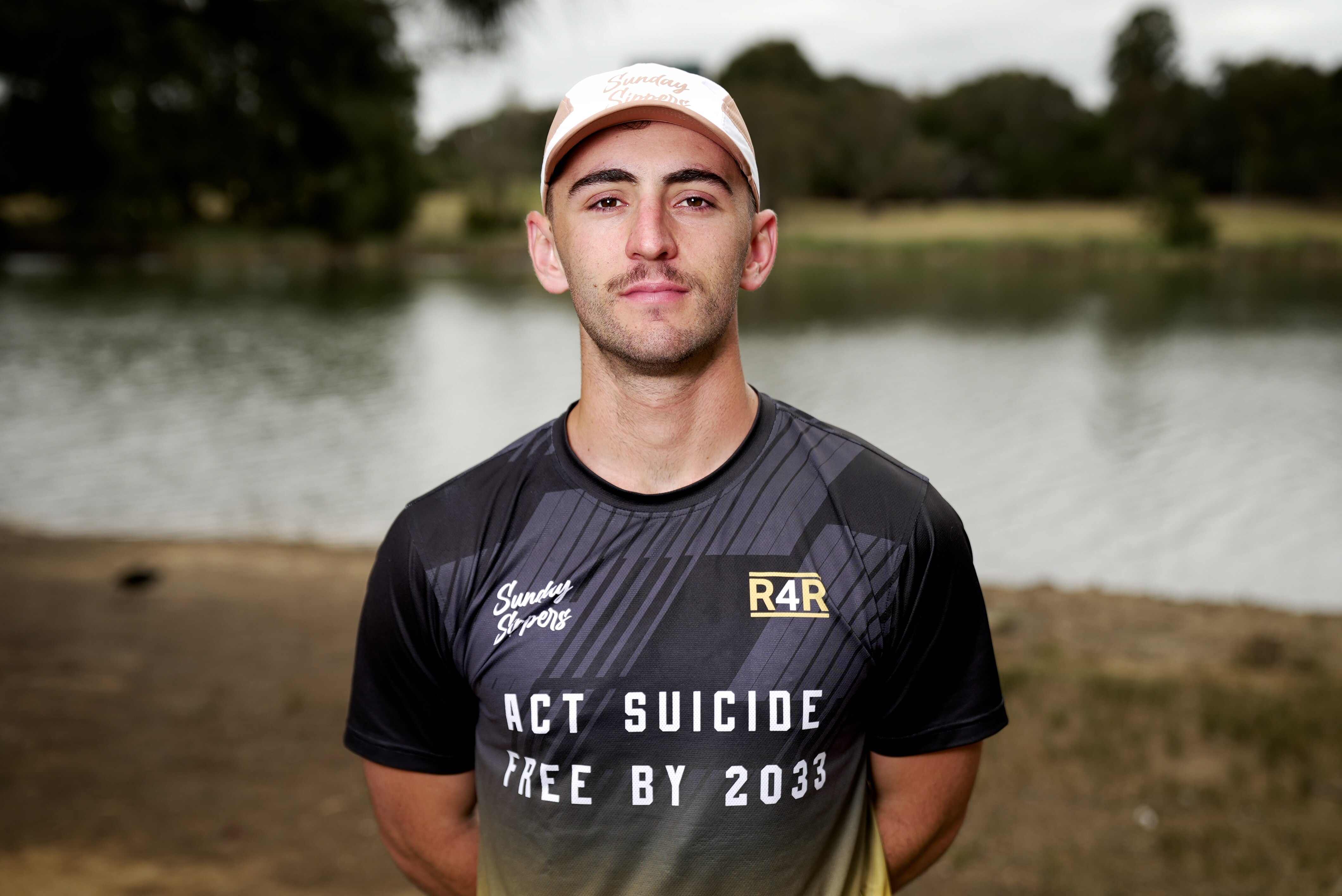 A man wearing a white cap and a black shirt with the words"ACT suicide free by 2033".