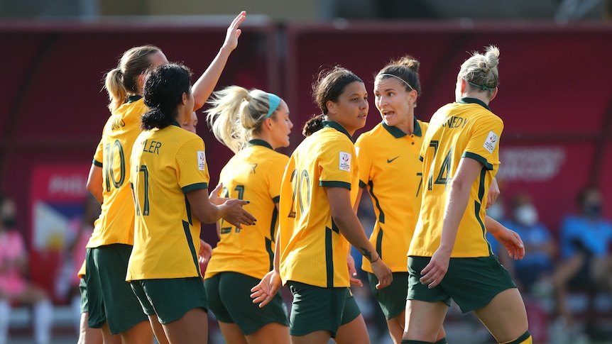 Australia soccer players walk in a group after scoring a goal in the Asian Cup