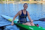 Pregnant woman sitting in kayak and smiling.