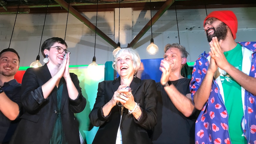 Elizabeth Watson-Brown with other Greens state MPs and Brisbane councillor, all clapping a happy on stage
