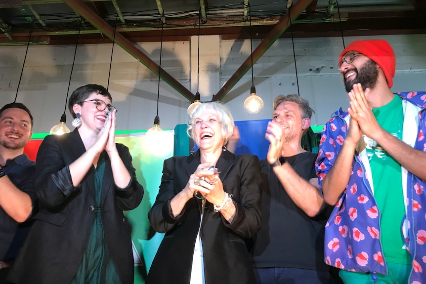 Elizabeth Watson-Brown with other Greens state MPs and Brisbane councillor, all clapping a happy on stage