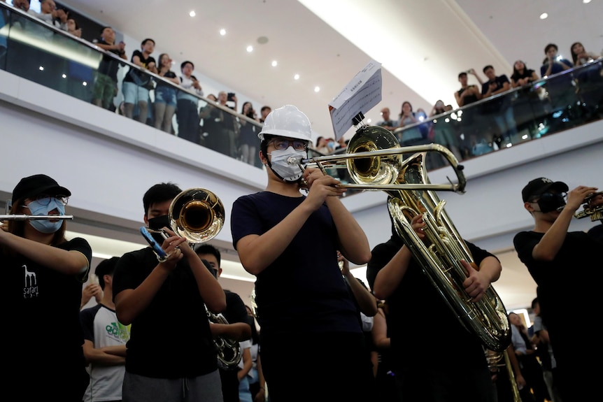 A brass band plays during a flash mob in a shopping mall. 
