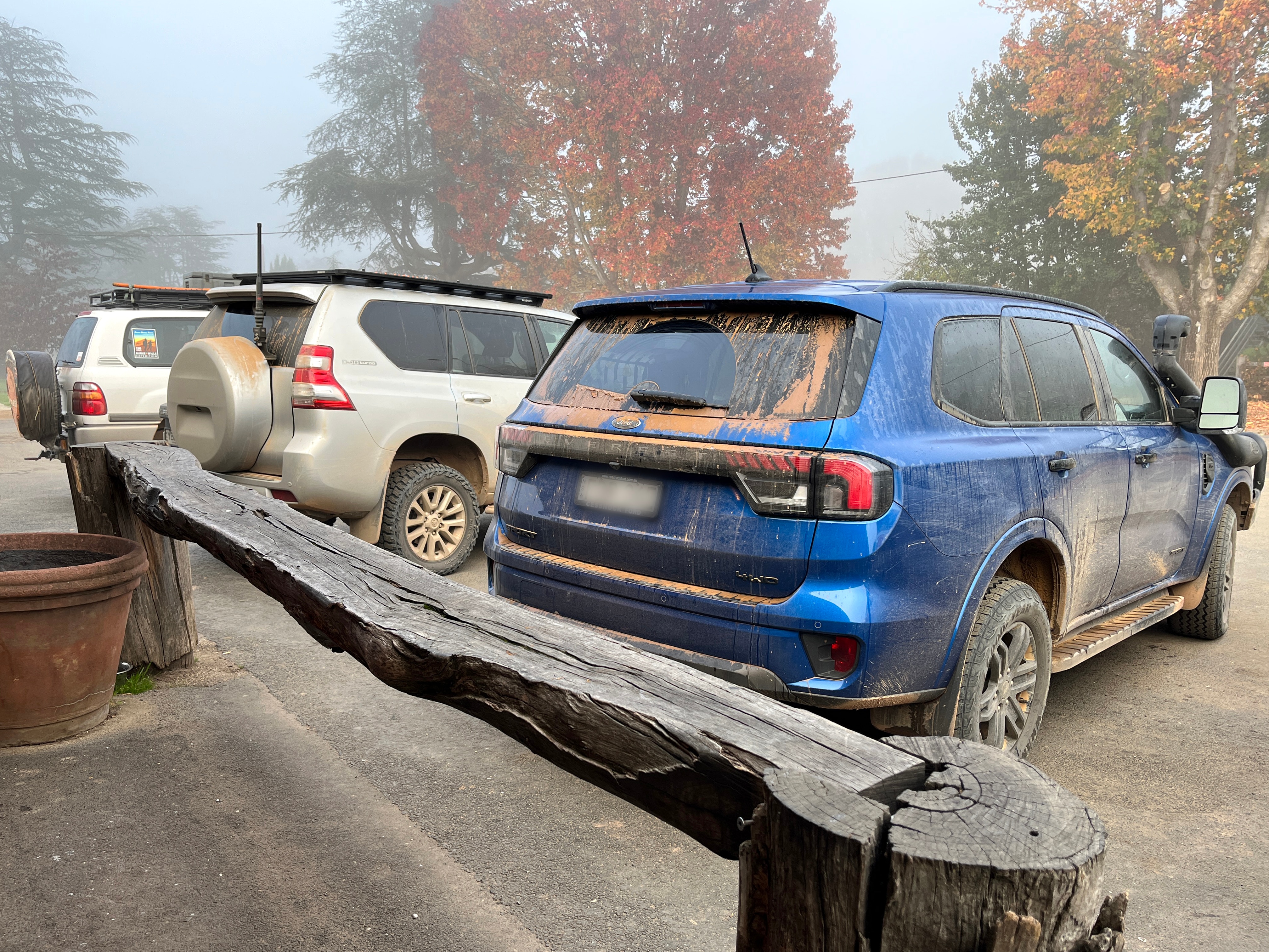 Three SUV cars lined up outside a pub, with autumn trees in the background.