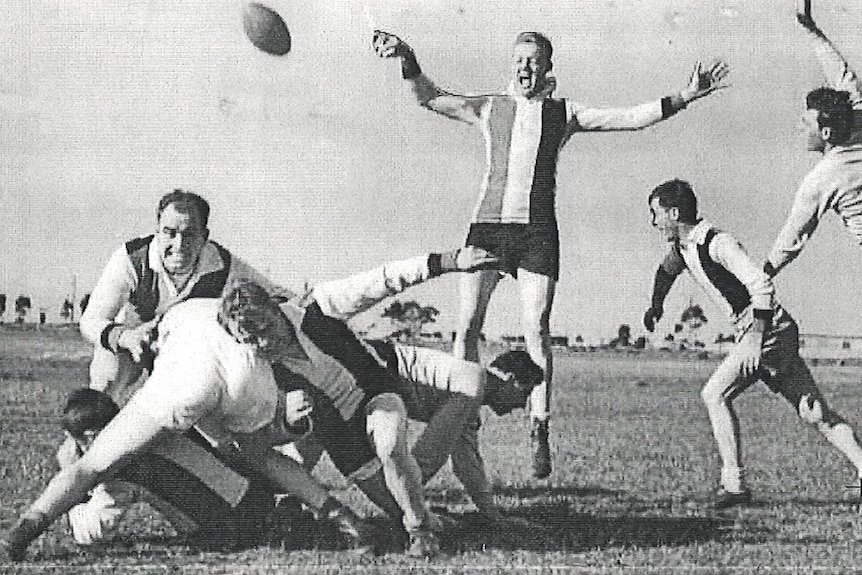 A black and white photo of soldiers playing football.