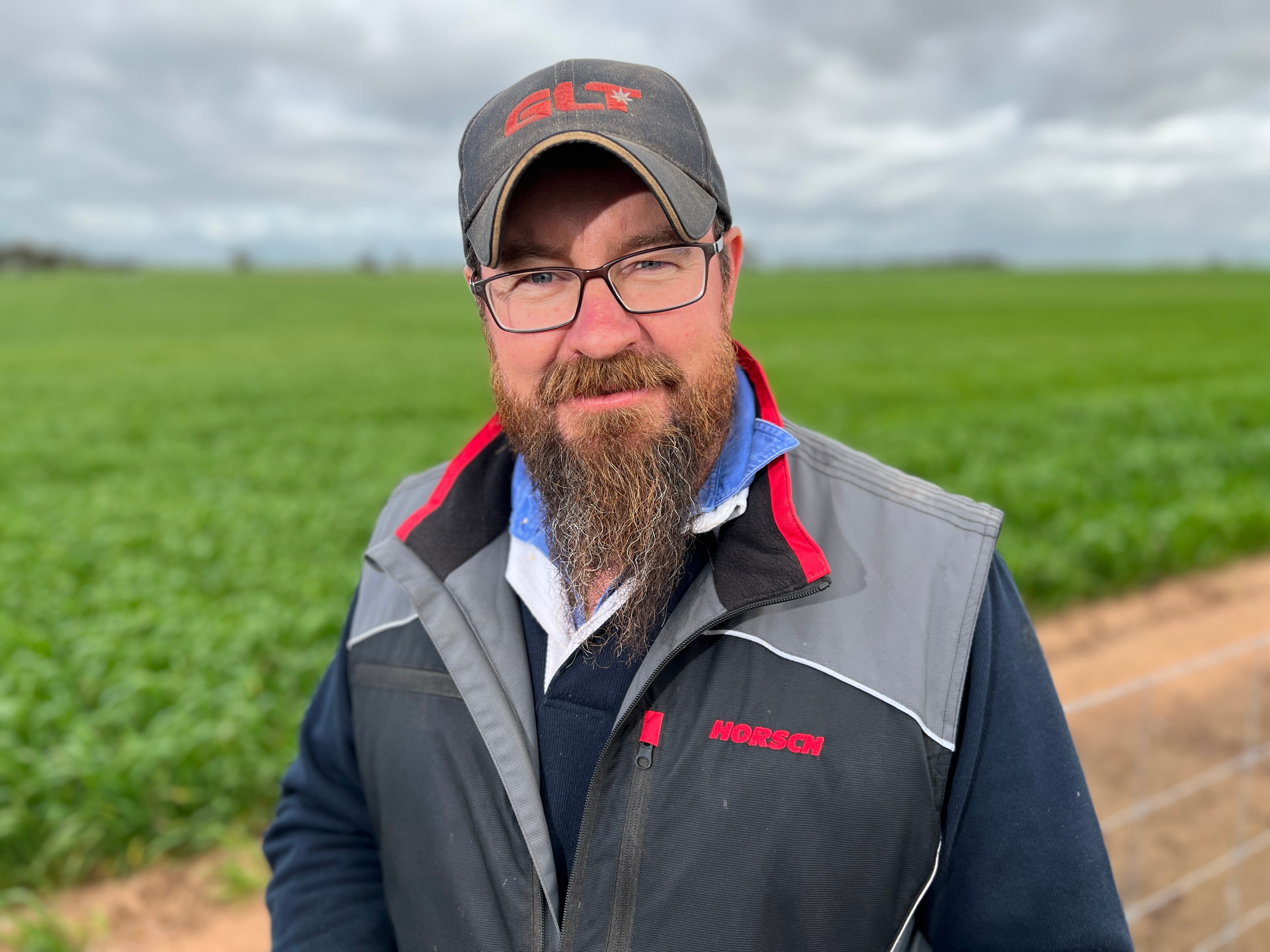 Ryan Milgate standing in a paddock of crop