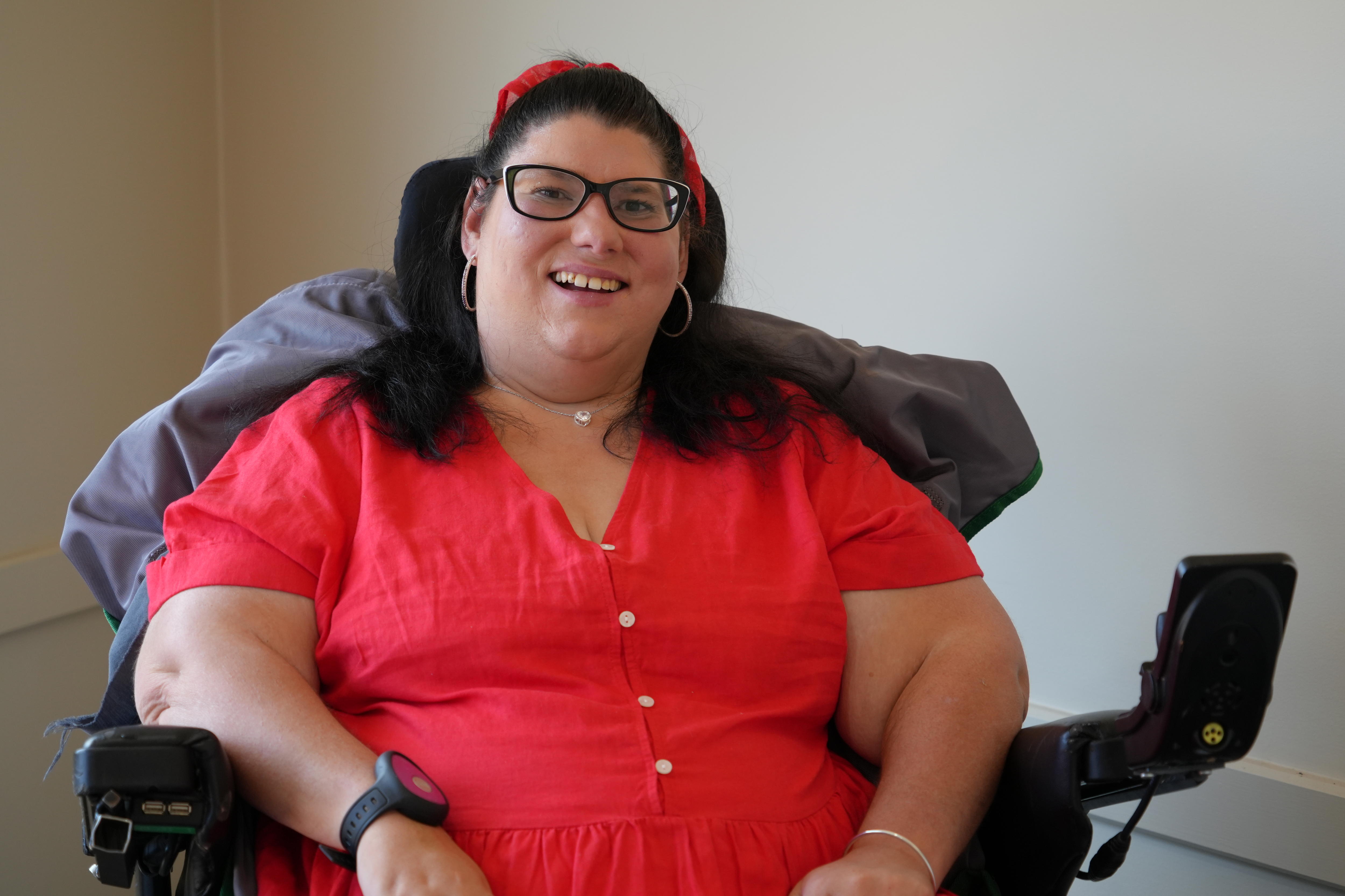 Una mujer sonríe a la cámara. 