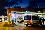 ambulances arrive at bundaberg hospital, a paramdic holds up tarpauline to block view