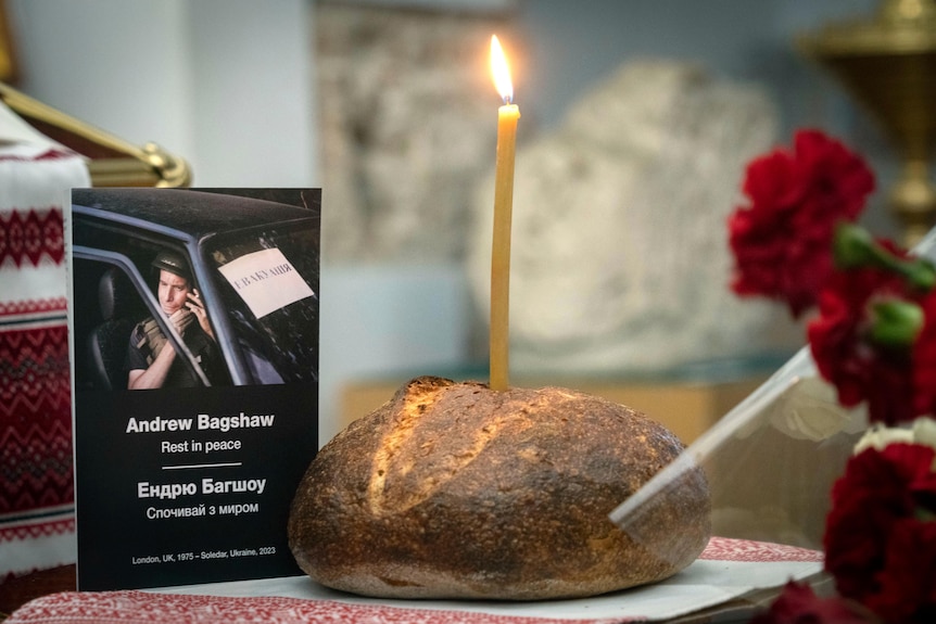 Andrew의 사진 앞에 있는 빵 한 덩어리에 촛불. 