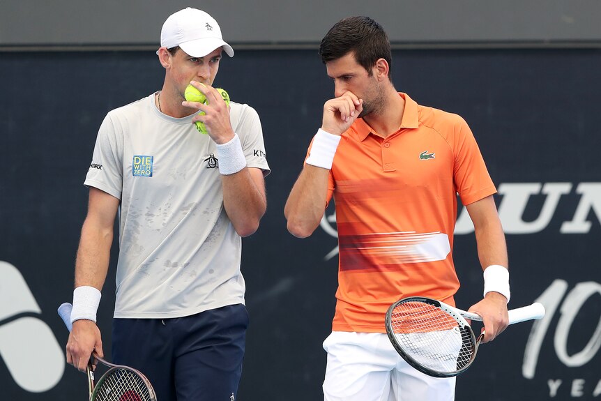 Two professional male tennis players chat during a doubles match at the Adelaide International.