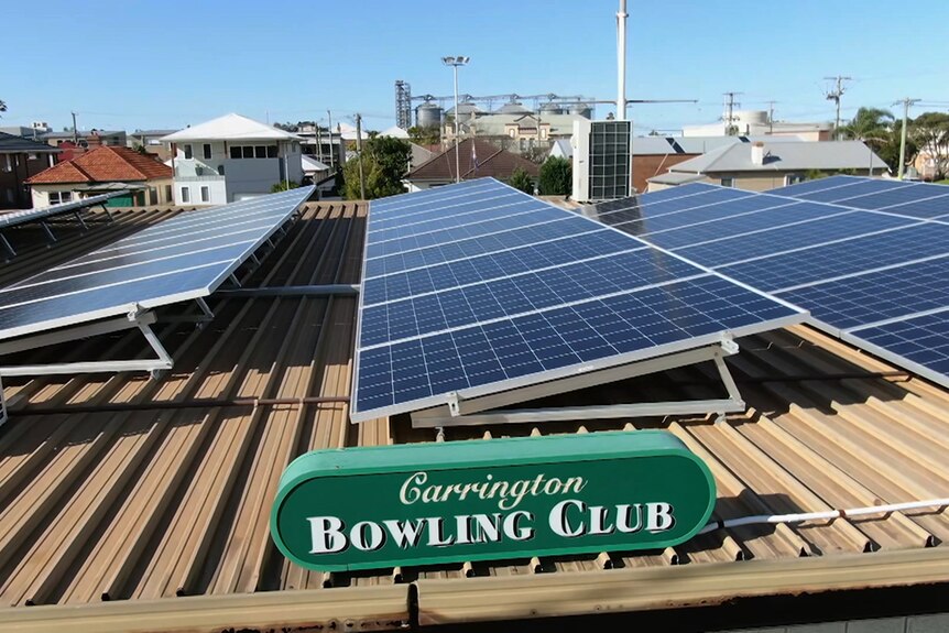 An aerial pic of solar panels on top of a club with a sign that says Carrington Bowling Club
