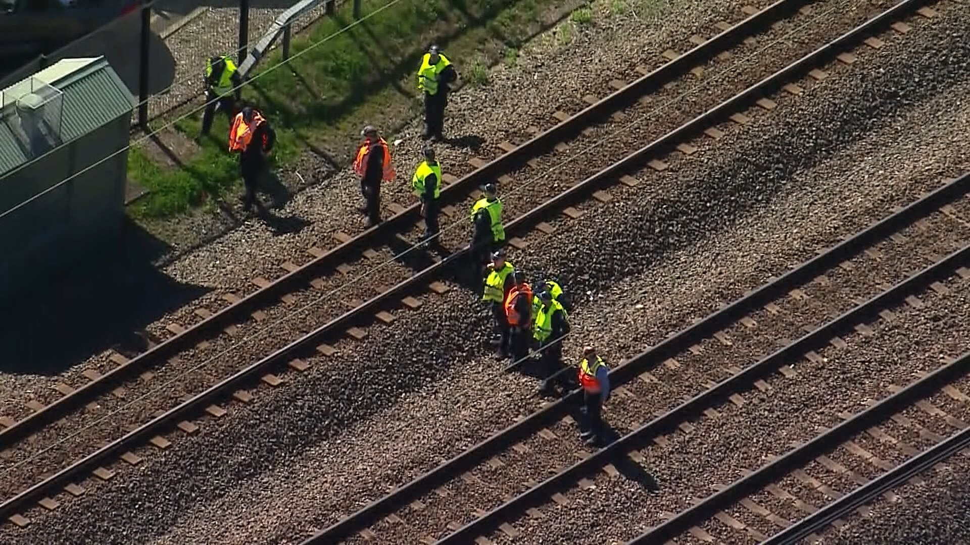 Police dressed in hi-vis searching for evidence on train tracks